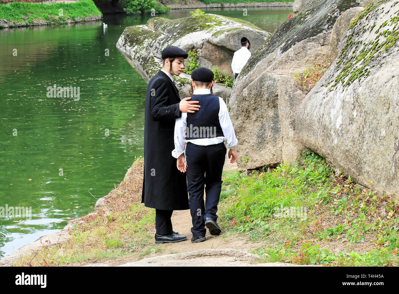 2 Junge, eine Familie der chassidischen Juden, Spaziergang im Park in Uman, Ukraine, das Jüdische Neue Jahr, Rosch-ha-Shana. Der ältere Bruder kümmert sich um die Jüngeren Stockfoto
