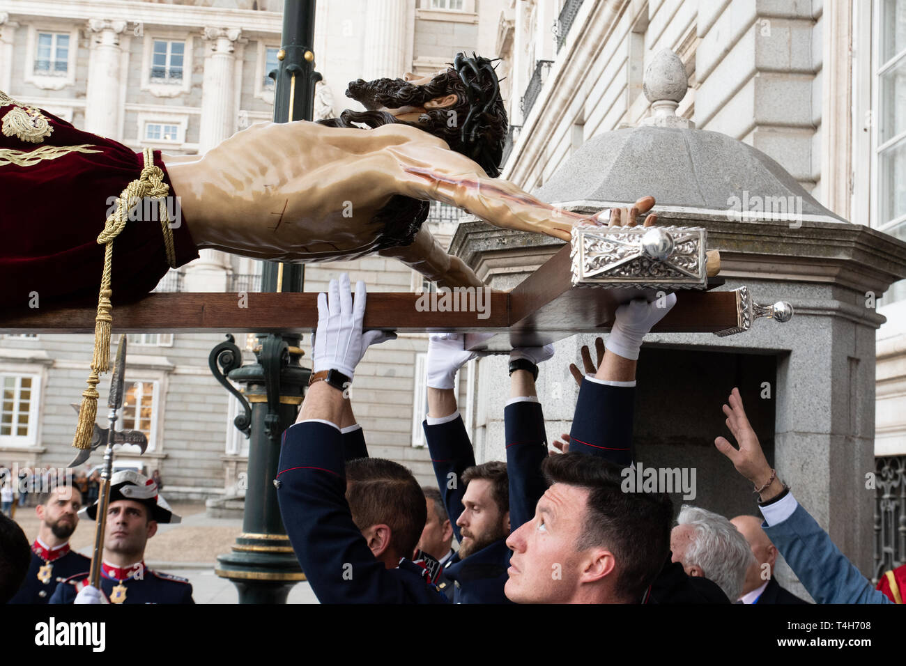 Madrid, Spanien. 16. April 2019. Mitglieder der Bruderschaft des "Cristo de los Alabarderos' halten Sie die Abbildung am Tor des Königlichen Palastes. Stockfoto