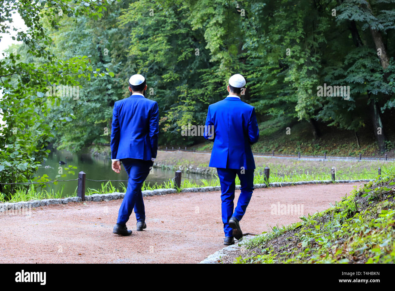 2 junge Männer, chassidischen Juden in blauen Anzügen und weißen Kappe Spaziergang in Uman. Die Ukraine, während das Jüdische Neue Jahr. Stockfoto