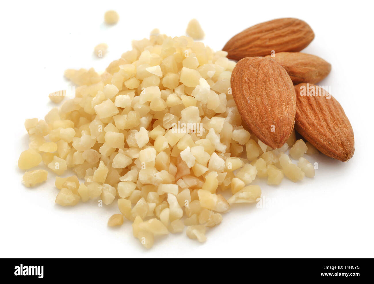 Kleine Stücke gehackten Mandeln mit ganzen, auf weißem Hintergrund Stockfoto
