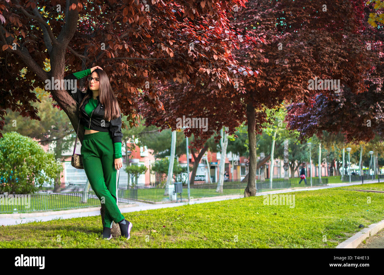 Murcia, Spanien, 15. April 2019: attraktive junge Frau steht von einem Vogel Kirschbaum im City Park suchen und Flirten, verführen mit Kamera im Herbst Saison. Stockfoto
