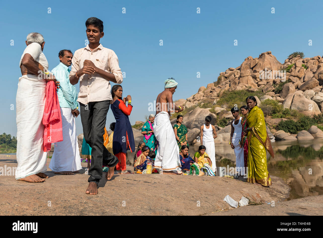 Gruppe von Menschen, die sich durch den Fluss in Hampi, Indien Stockfoto