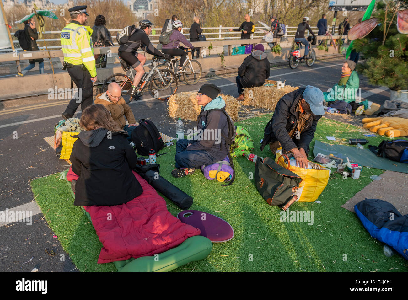 London, Großbritannien. 17. Apr 2019. Morgen auf der Waterloo Bridge sieht das Lager wach und Pendler machen ihre Fortschritte zu Fuß und mit dem Fahrrad über den Fluss - Tag 3 - Demonstranten vor dem Aussterben Rebellion Block mehrere Kreuzungen in London als Teil der laufenden Aktion, die von der britischen Regierung, auf die 'Klima chrisis" verlangen. Die Aktion ist Teil einer international koordinierten protestieren. Credit: Guy Bell/Alamy leben Nachrichten Stockfoto