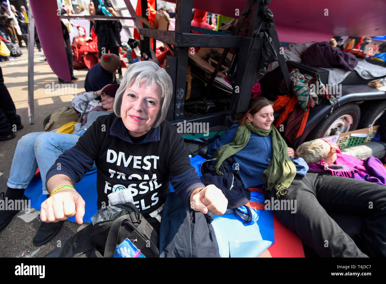 London, Großbritannien. 17. April 2019. Eine Demonstrantin Tragen eines Theresa May face Maske andere Demonstranten verkettete rund um die Basis der Hip der Wahrheit" in Oxford Circus in London: Internationale Rebellion', am dritten Tag eines Protestes vom Aussterben Rebellion organisiert, fordert, dass Regierungen Maßnahmen gegen den Klimawandel ergreifen verbindet. Marble Arch, Oxford Circus, Piccadilly Circus, Waterloo Bridge und Parlament Platz haben von Aktivisten, die in den letzten 3 Tagen gesperrt worden. Die Polizei hat einen Abschnitt 14 Um die Demonstranten bei Marble Arch einzuberufen, nur so, dass der Protest können weiterhin ausgestellt. Gutschrift: Stockfoto