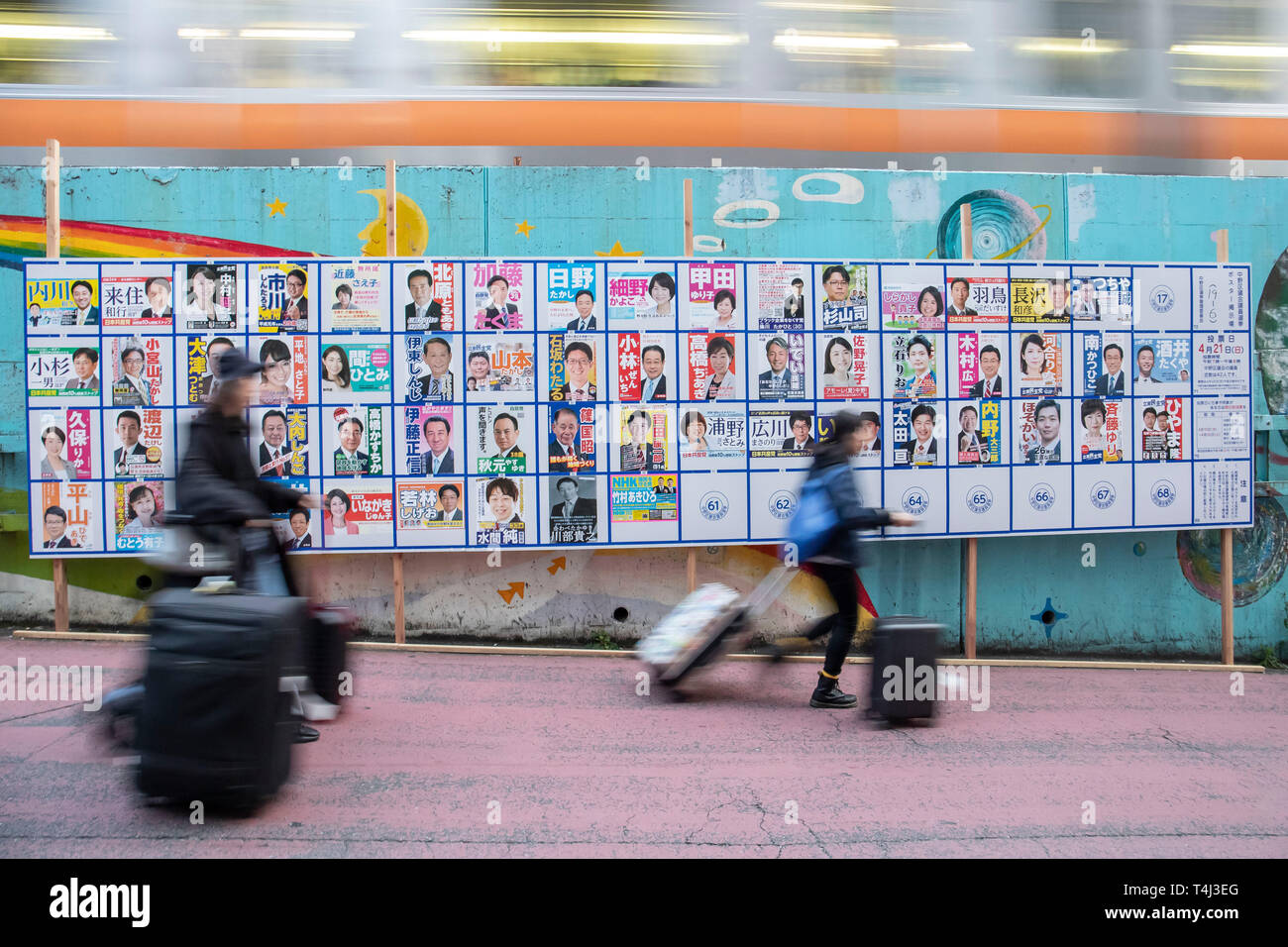 Tokio, Japan. 17 Apr, 2019. Fußgänger vorbei an eine Plakatwand mit Postern Kandidaten für Unified lokale Umfragen für April 21 errichtet, außerhalb Nakano Station. Renho, Mitglied des konstitutionellen Demokratischen Partei Japans (CDP) zeigten die Unterstützung für die Partei anderen Kandidaten vor der Unified Kommunalwahlen, die am 21. April stattfinden wird. Credit: Rodrigo Reyes Marin/LBA/Alamy leben Nachrichten Stockfoto