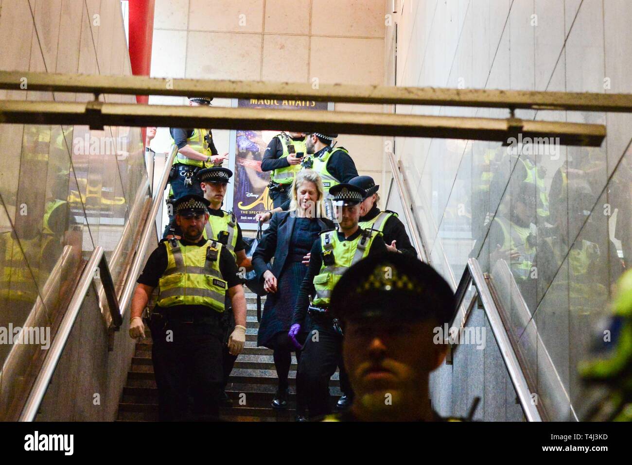 London, Großbritannien. 17 Apr, 2019. Ein Klimawandel Demonstrantin, die sich auf dem Dach eines DLR-Zug am Canary Wharf DLR Station geklebt wird von der Polizei geführt. Credit: Claire Doherty/Alamy leben Nachrichten Stockfoto