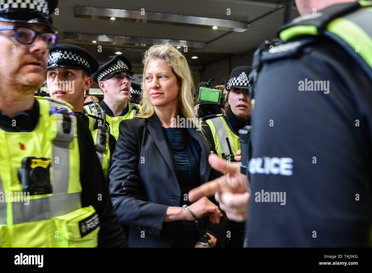 London, Großbritannien. 17 Apr, 2019. Ein Klimawandel Demonstrantin, die sich auf dem Dach eines DLR-Zug am Canary Wharf DLR Station geklebt wird von der Polizei geführt. Credit: Claire Dohert/Alamy leben Nachrichten Stockfoto