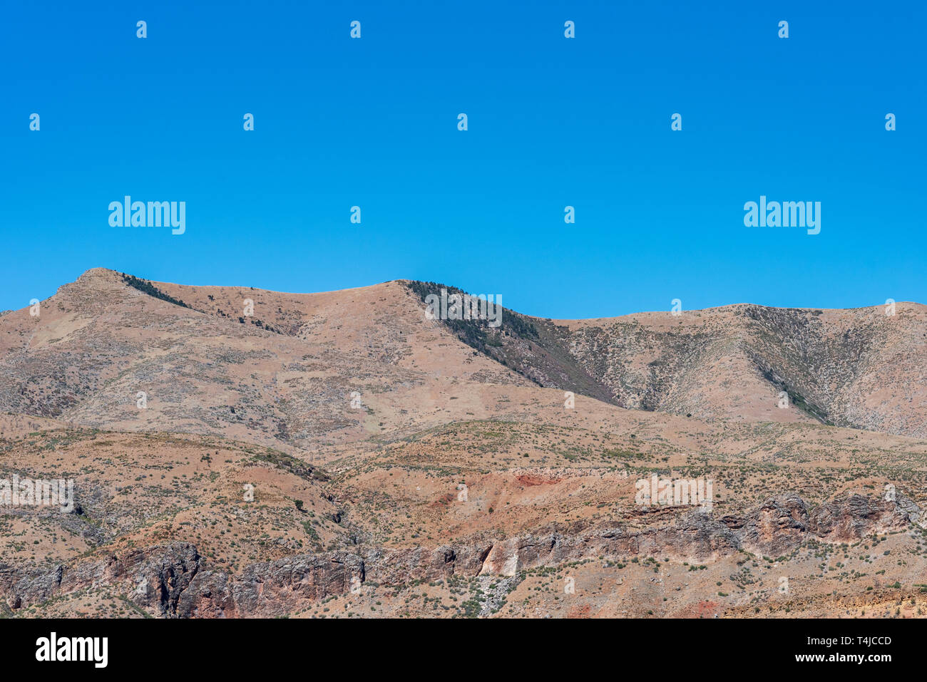 Braun Wüste Berge mit felsigen Klippen unter einem strahlend blauen Himmel. Stockfoto