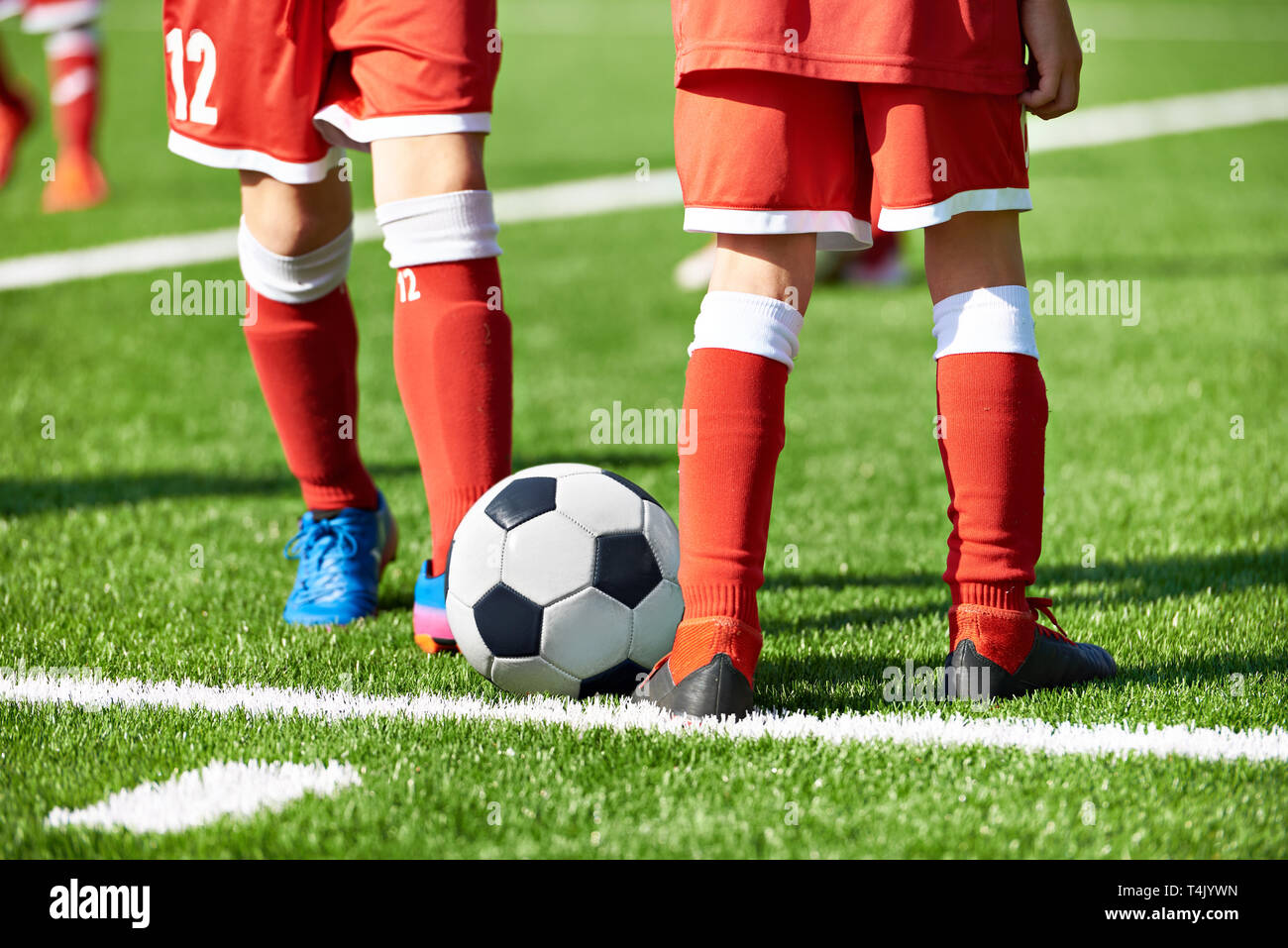 Jungen Fußball Spieler in roten Sport Uniform mit einem Ball auf dem Fußballplatz Stockfoto