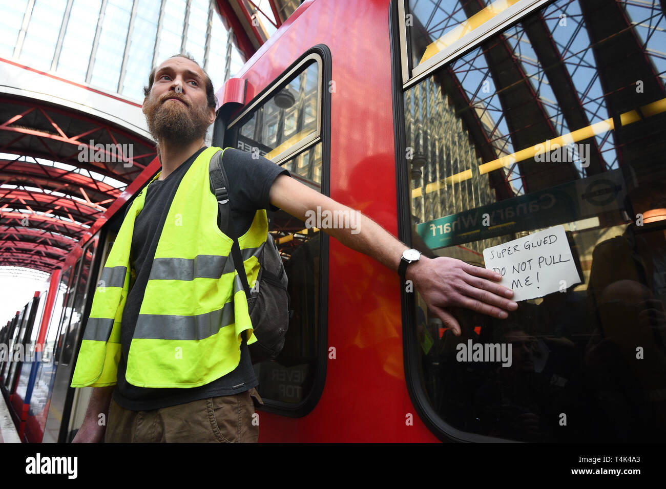 Ein Klima Aktivist, nachdem er sich zu einem Dockland Light Railway Station in Canary Wharf im Osten Londons geklebt als Teil der laufenden Klimawandel Proteste in der Hauptstadt. Stockfoto