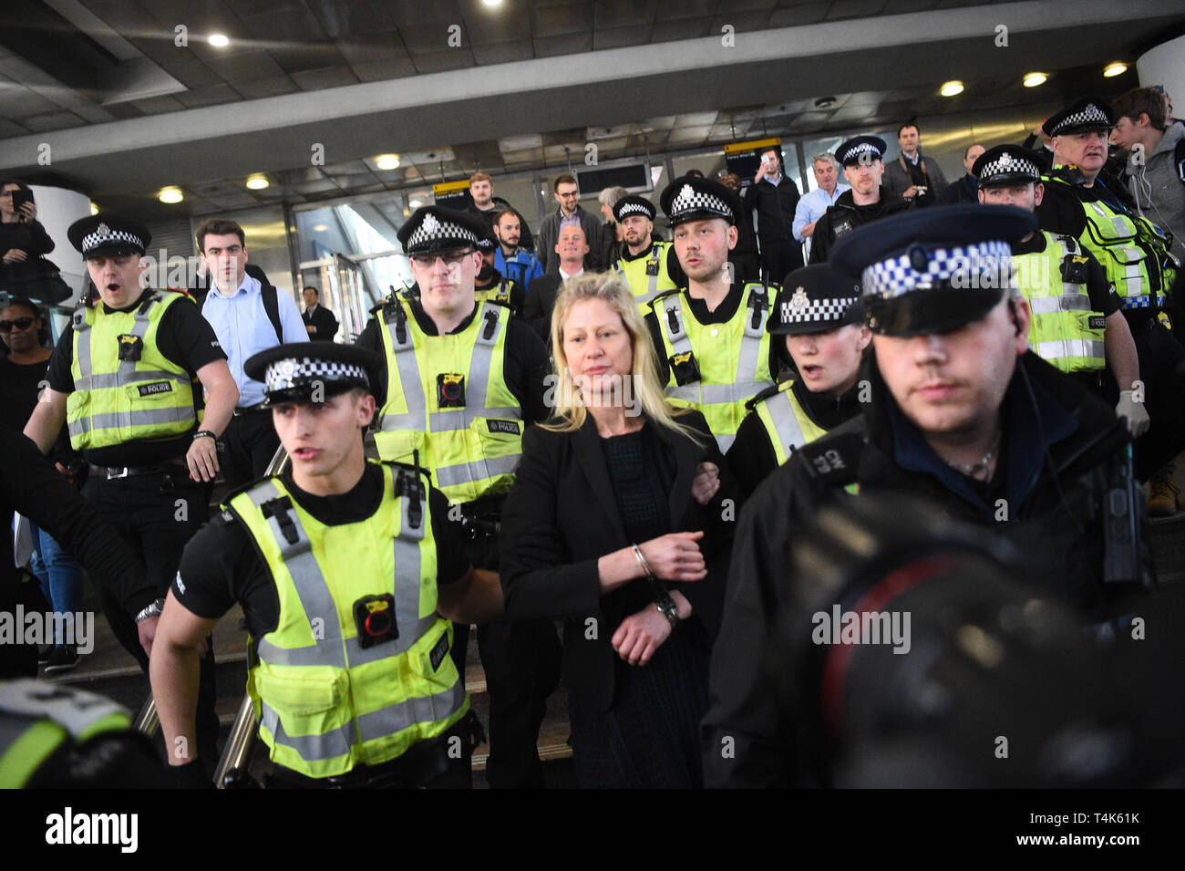 Eine von zwei Klima Aktivisten sind weg von der Polizei geführt, nachdem sie über einen Dockland Light Railway Station in Canary Wharf im Osten Londons hat im Rahmen der laufenden Klimawandel Proteste in der Hauptstadt. Stockfoto