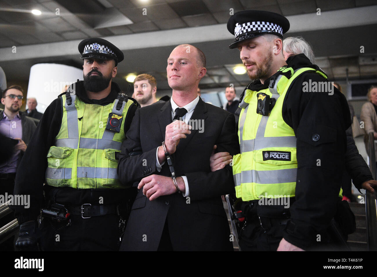 Eine von zwei Klima Aktivisten sind weg von der Polizei geführt, nachdem sie über einen Dockland Light Railway Station in Canary Wharf im Osten Londons hat im Rahmen der laufenden Klimawandel Proteste in der Hauptstadt. Stockfoto