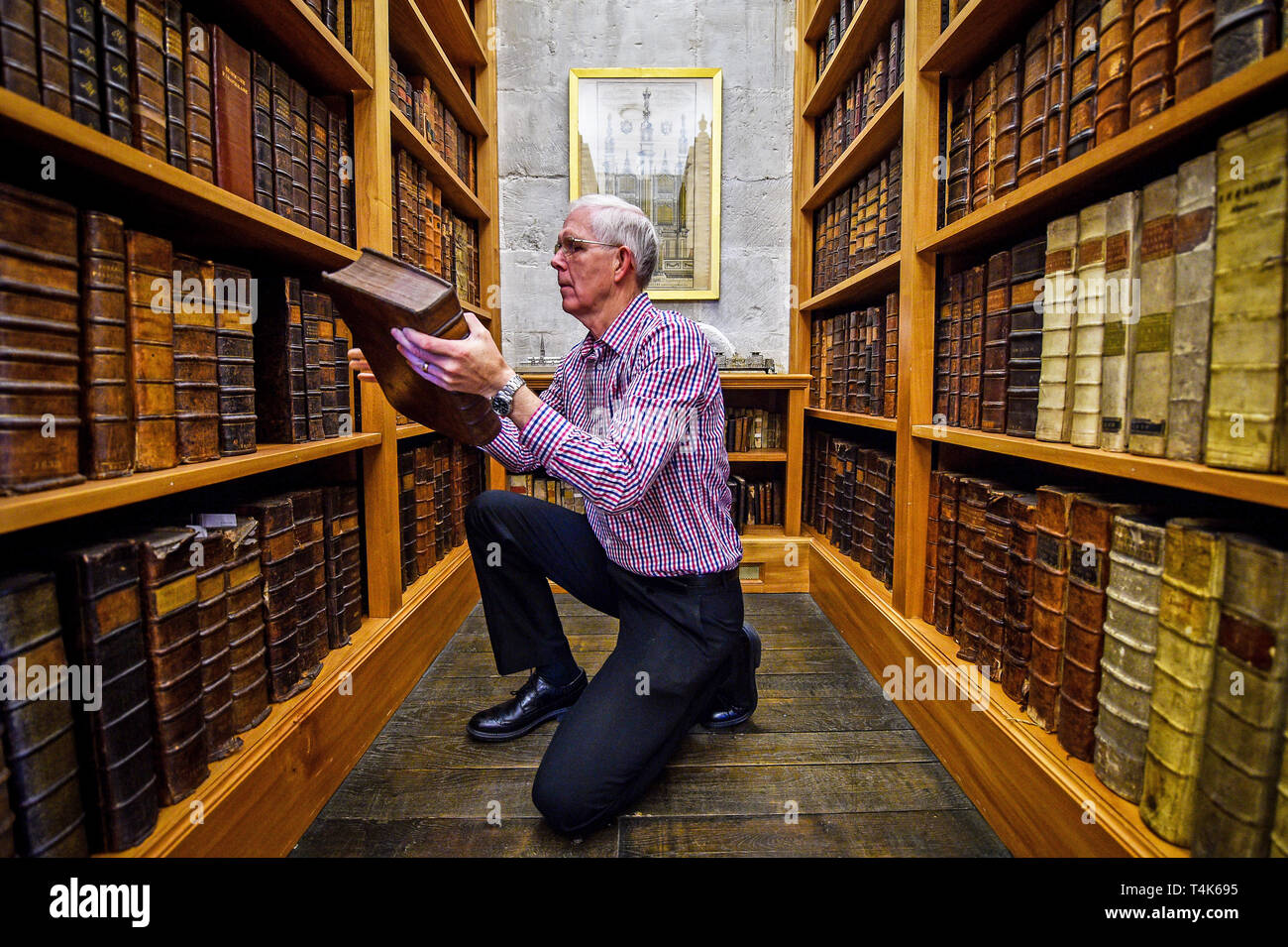 Die Kathedrale von Salisbury Archivar Colin Malcolm griffe Leder - gebundene Bücher im 15. Jahrhundert die Bibliothek der Kathedrale, wo ein Projekt zum Katalog, sauber und finden Sie mehr über die seltene Buch Sammlung ist im Gange. Stockfoto