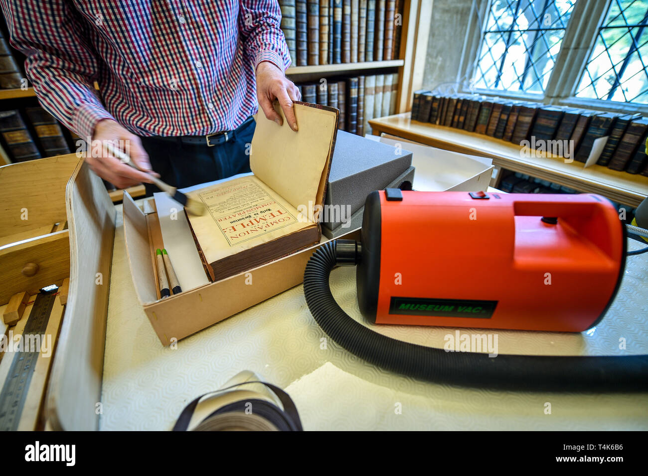 Die Kathedrale von Salisbury Bibliothek ehrenamtliche Colin Malcolm vorsichtig Bürsten die inneren Seiten eines Buches, das im 15. Jahrhundert die Bibliothek der Kathedrale, wo ein Projekt zum Katalog, sauber und finden Sie mehr über die seltene Buch Sammlung ist im Gange. Stockfoto