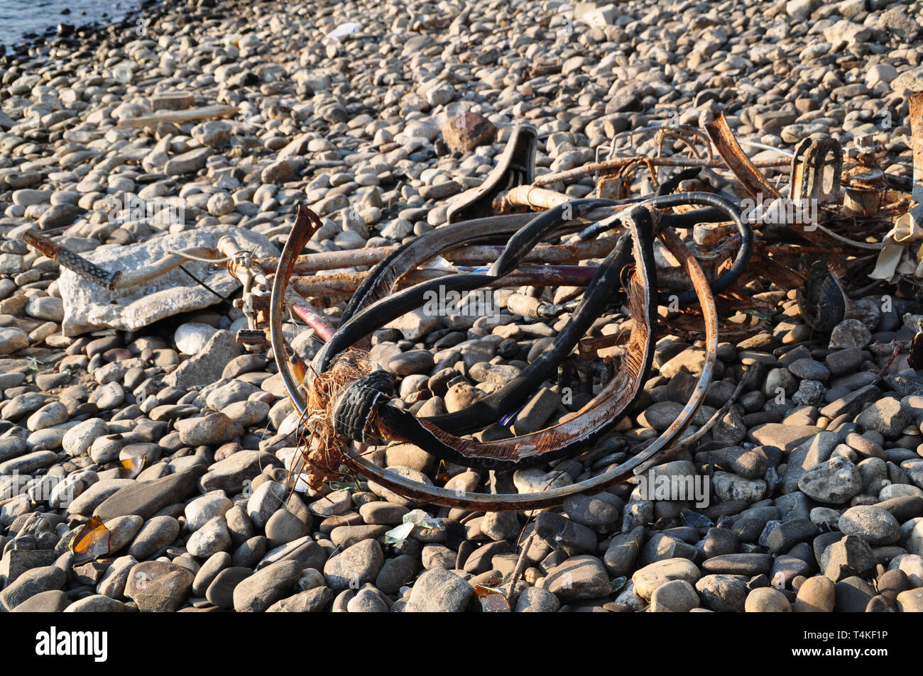 Eine verrostete Fahrrad liegt am Ufer des Rheins. Es war in den Rhein geworfen und angeschwemmt. Es ist verbogen und faul. Stockfoto