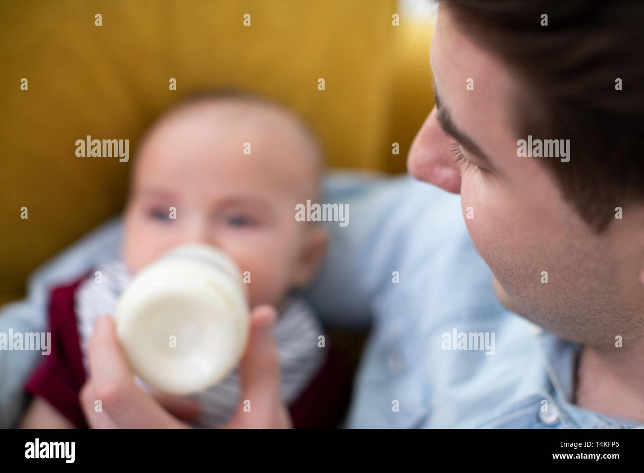 Nahaufnahme der liebevollen Fütterung baby Sohn mit Flasche zu Hause Stockfoto