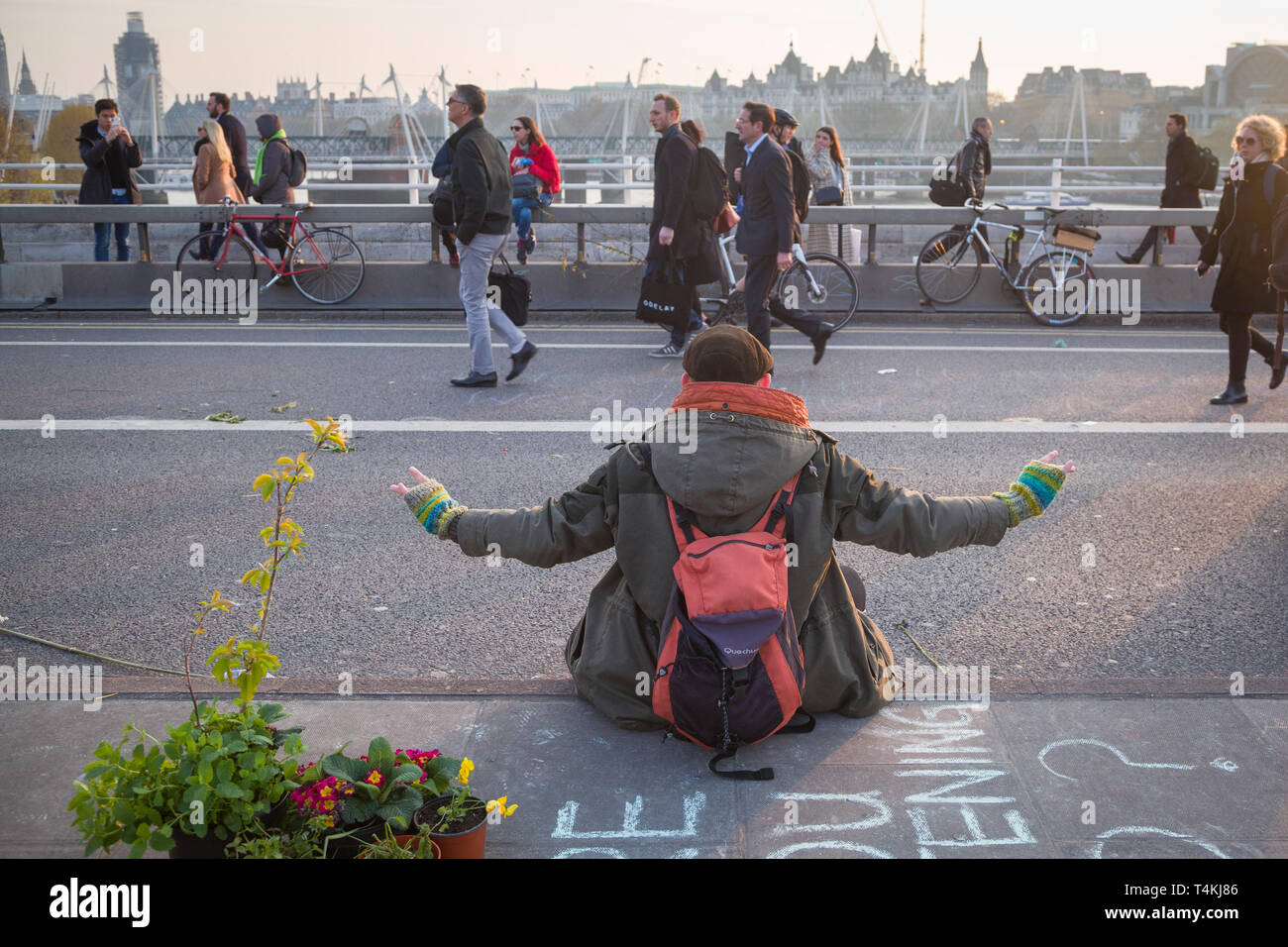 Ein Demonstrator meditiert auf der Waterloo Bridge für das Aussterben Rebellion Demonstration als Menschen gehen durch Stockfoto