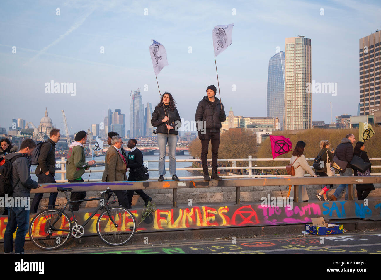 Zwei Demonstranten stand halten Fahnen auf der Waterloo Bridge für das Aussterben Rebellion Demonstration mit der Stadt London hinter Stockfoto