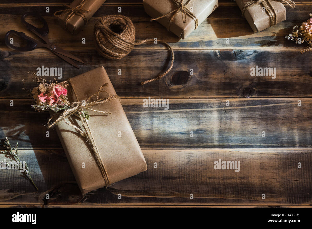 Noch immer leben Schoß der schönen kleinen handmade DIY Geschenkbox (Paket) mit Blumen und dekorative Seil auf Holz Hintergrund. Vintage Retro Style. Flach Stockfoto