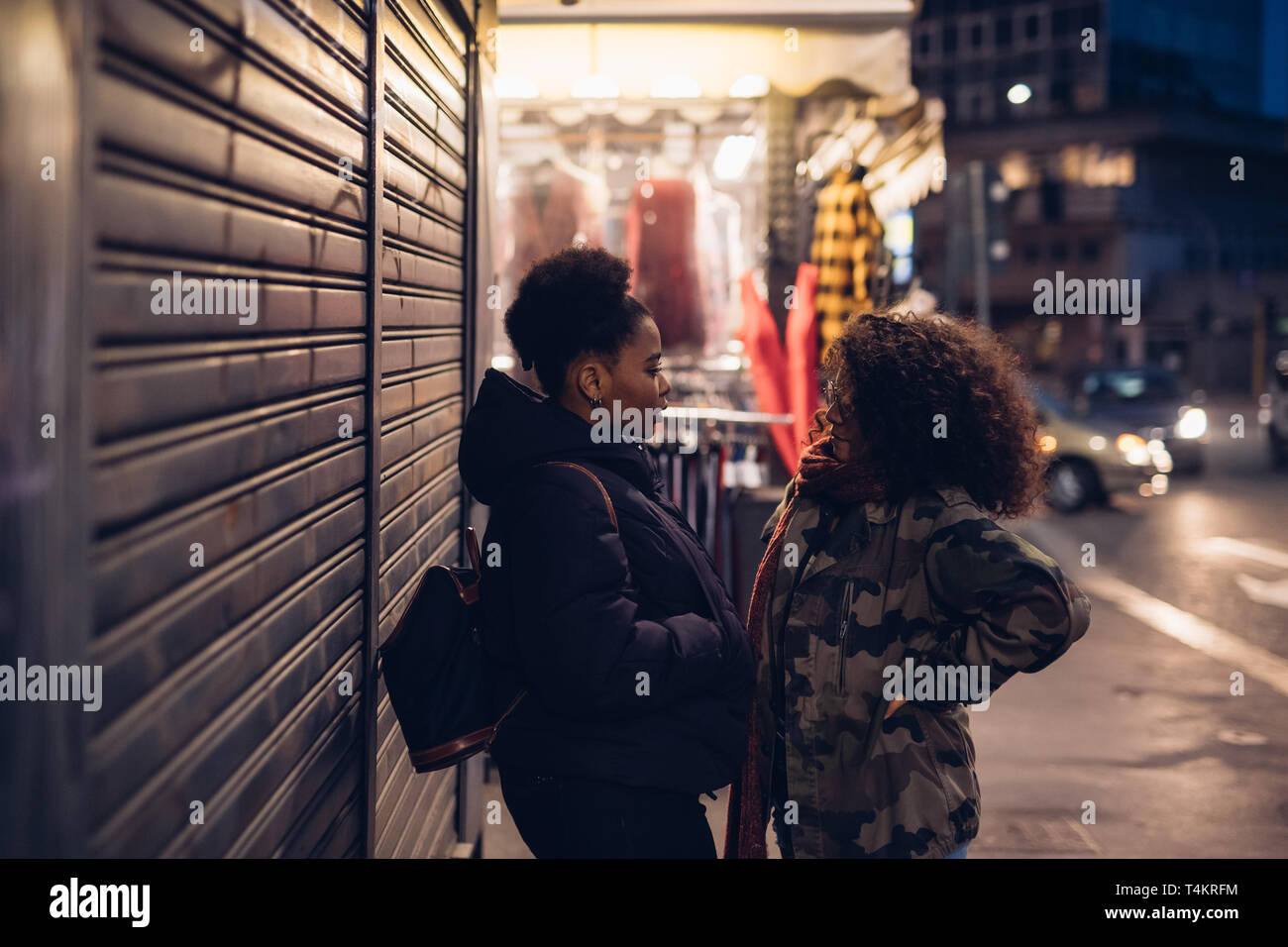 Zwei lockig und brunette Mädchen conversating in der Stadt - Interaktion, Kommunikation, Wettbewerb Stockfoto
