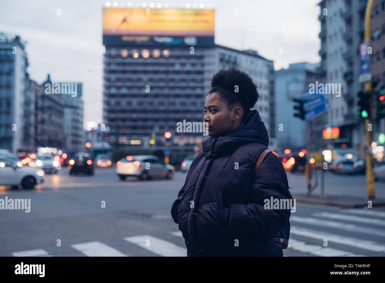 Jung und gekräuselte schwarze Mädchen auf der Straße mit Blick auf die Zukunft - Ausdrucksstarke, Metropolitan, Beobachten Stockfoto