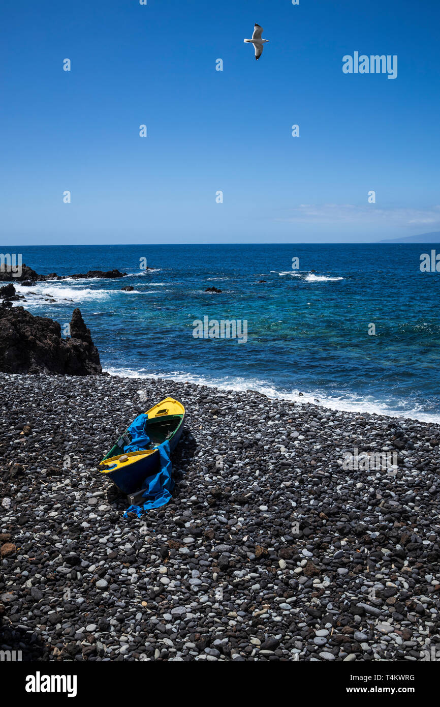 Alten hölzernen Ruderboot auf einem steinigen Strand in einer Bucht bei Fonsalia, mit Möwen fliegen Overhead, Playa San Juan, Teneriffa, Kanarische Inseln, Spanien Stockfoto