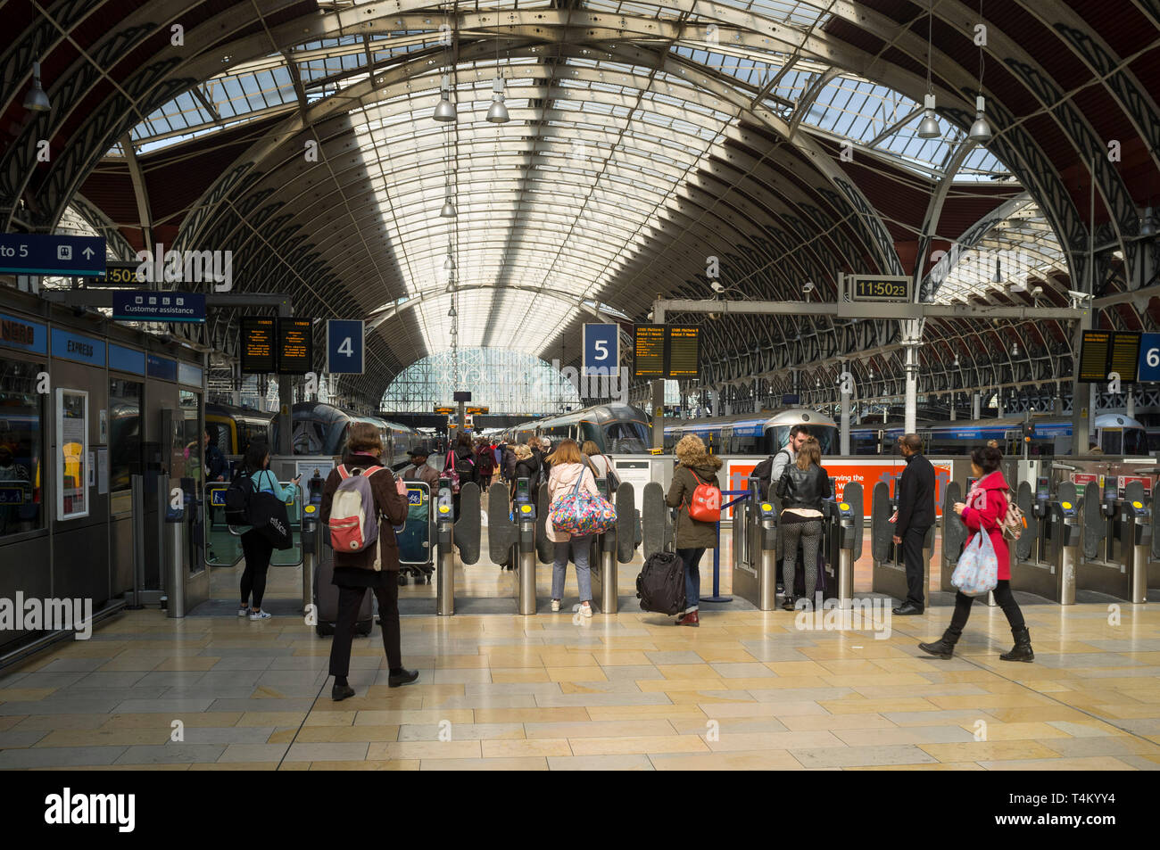Reisende gehen durch die Drehkreuze zu ihrer Züge am Bahnhof Paddington, London Stockfoto