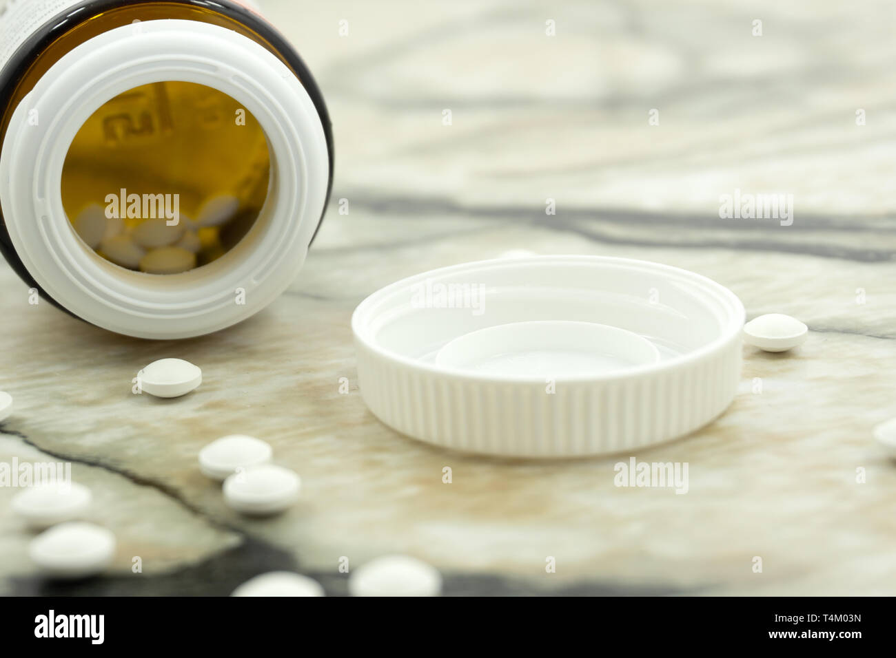 Closeup viele Vitamine C Tablet vor offenen Deckel Flasche in Weiß isoliert Hintergrund Stockfoto