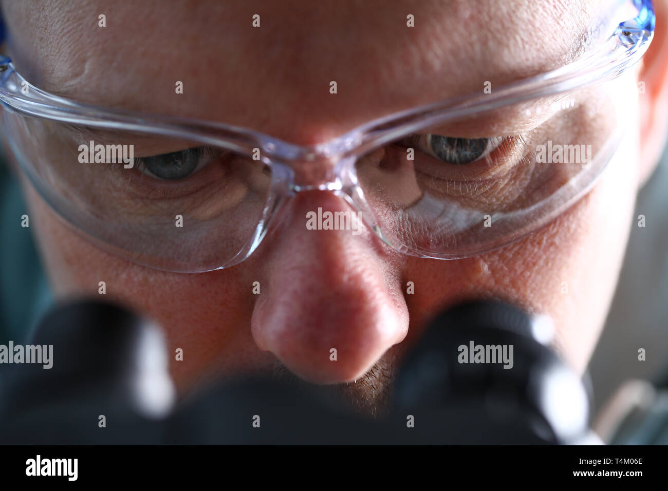 Laboratory Assistant Augen am Mikroskop tragen Schutzbrille Stockfotografie  - Alamy