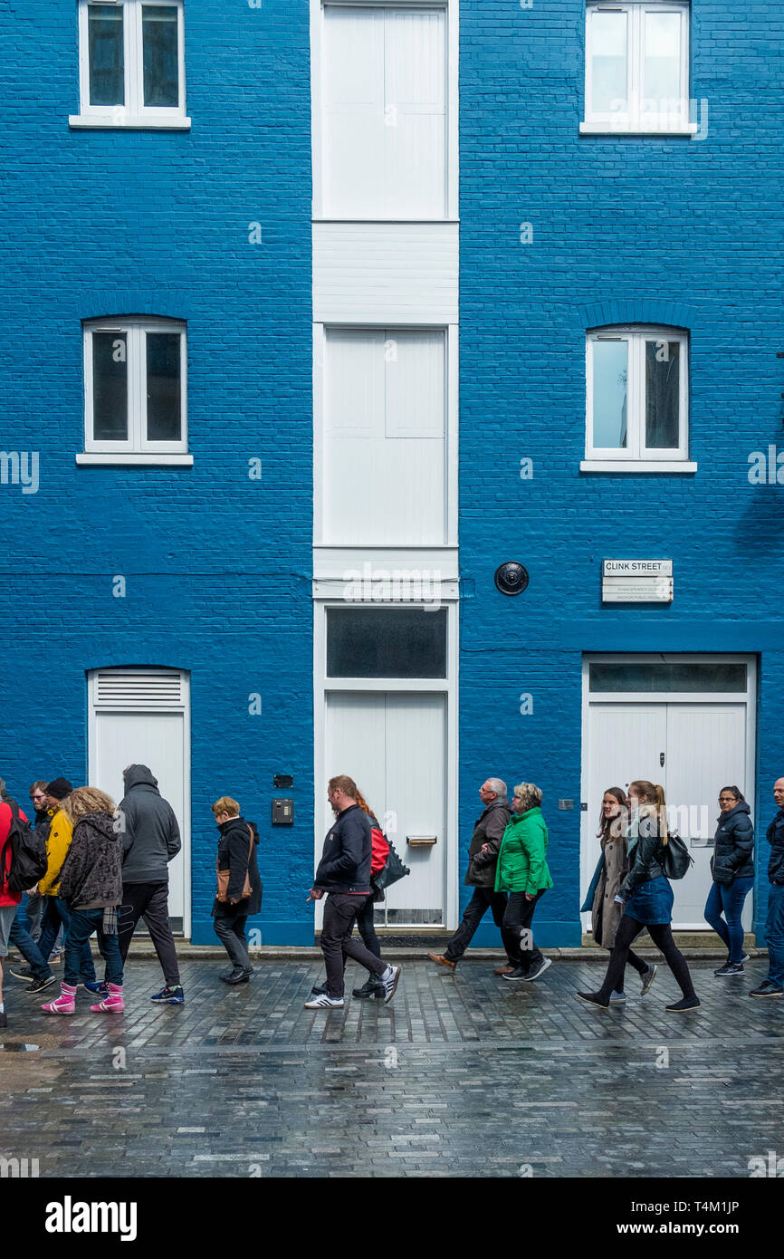 Eine Gruppe von Touristen vorbei gehen. ein Gebäude in Blau und Weiß in den Knast Street in London. Stockfoto
