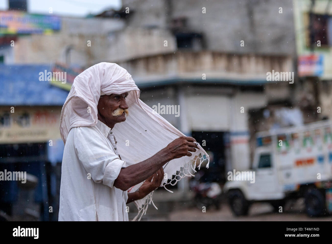 Alter Mann mit einem großen weißen Schnurrbart legte seinen Turban in einem ländlichen Dorf in Rajasthan, Indien Stockfoto