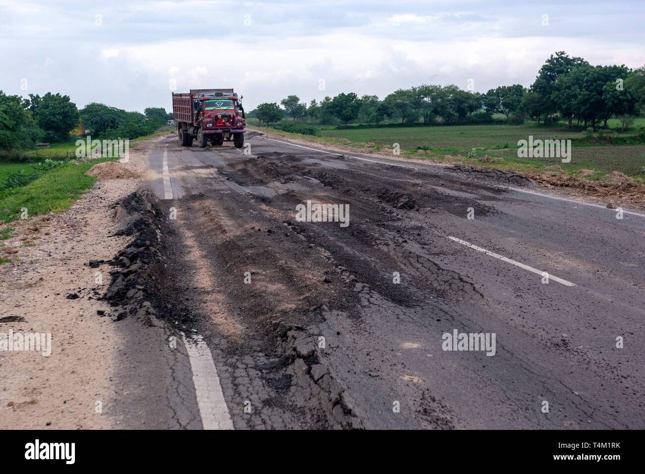 Lkw versuchen, große Schlaglöcher in eine Verformung Straße in Rajasthan, Indien zu vermeiden. Stockfoto