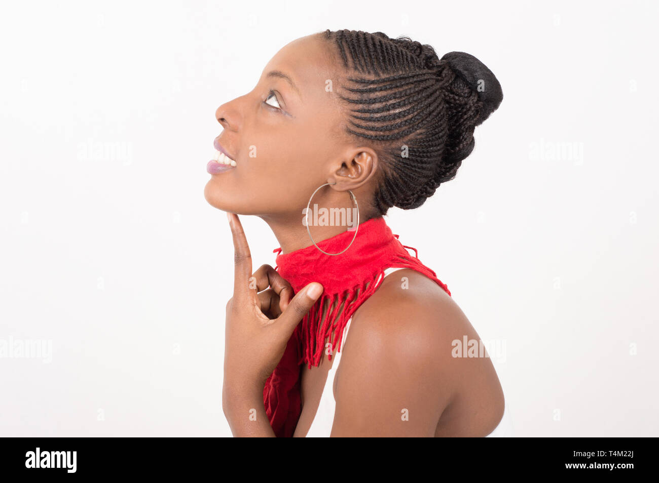 Glücklich und gequälten Frau mit einer schönen Haut trägt einen roten Schal um den Hals und sitzt im Profil über Ihre auf einem hellen Hintergrund Stockfoto