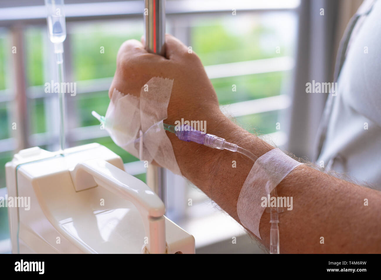 Close-up. Männliche hand mit Tropfer während der Chemotherapie in einem Krankenhaus. Hand mit einem Dropper. Gesundheit ist ein Thema der Gesundheit und Heilung Stockfoto