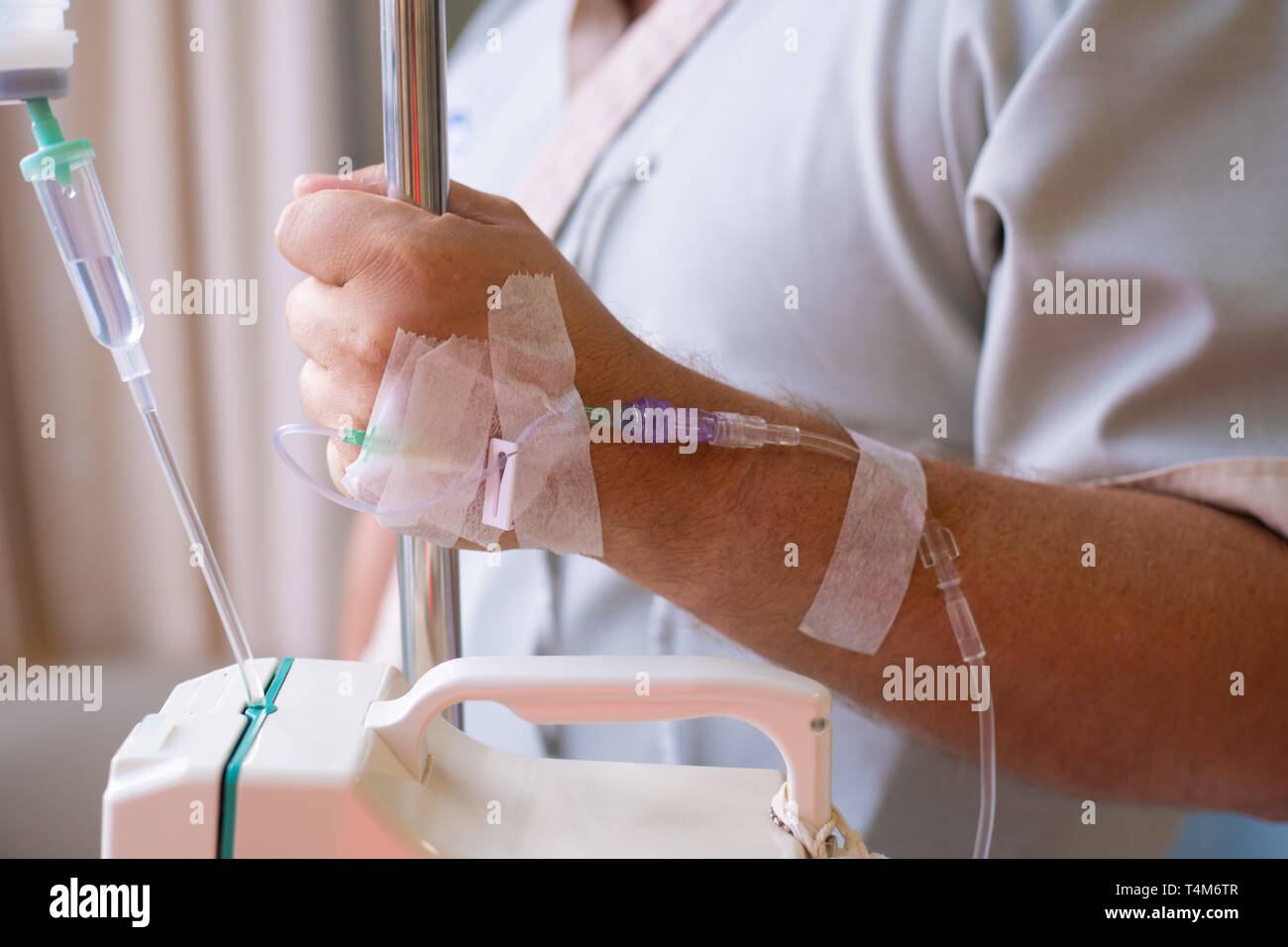 Close-up. Männliche hand mit Tropfer während der Chemotherapie in einem Krankenhaus. Hand mit einem Dropper. Gesundheit ist ein Thema der Gesundheit und Heilung Stockfoto