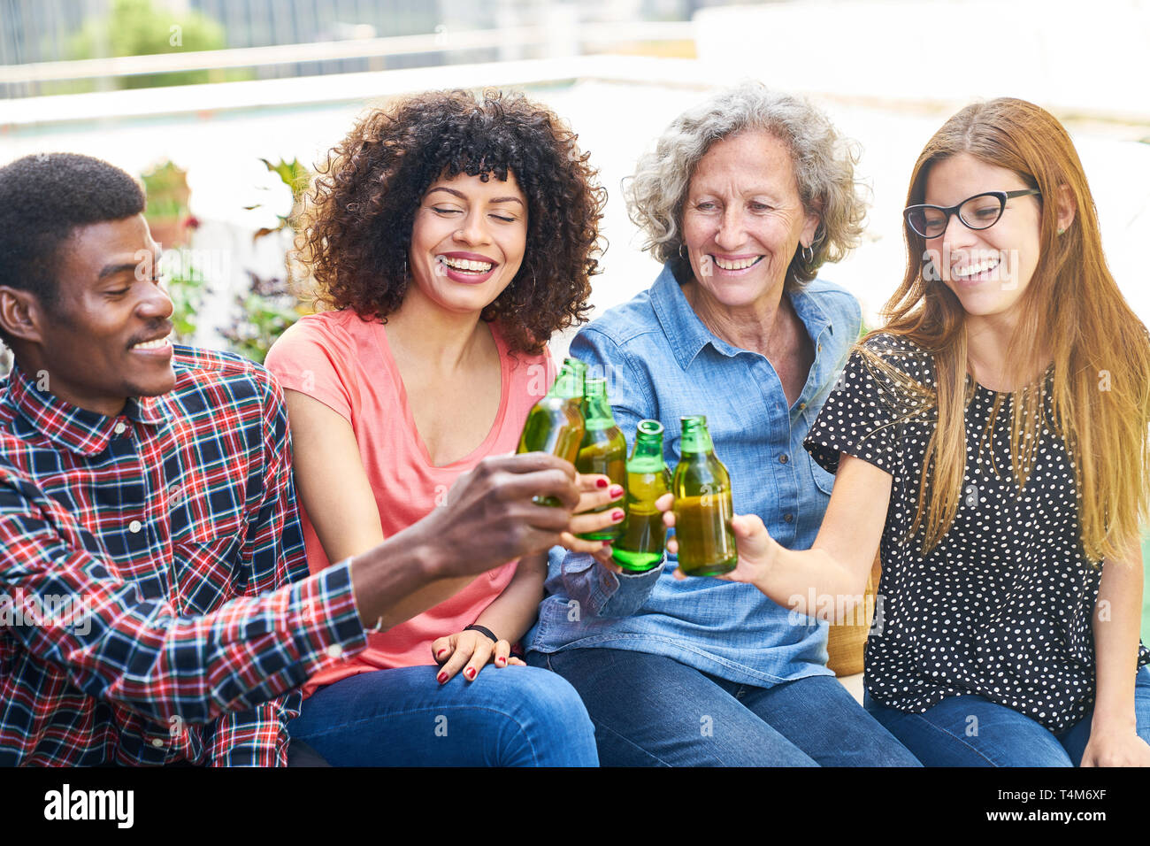 Gruppe von Freunden in das Toasten mit einer Flasche Bier auf einer Party in der freien Zeit Stockfoto