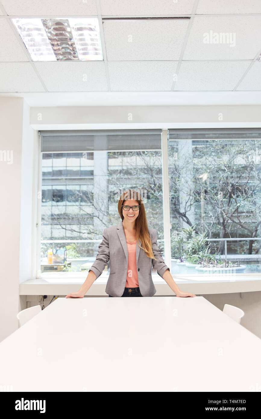 Young Business Frau mit Selbstvertrauen in Coworking Büro am Konferenztisch Stockfoto