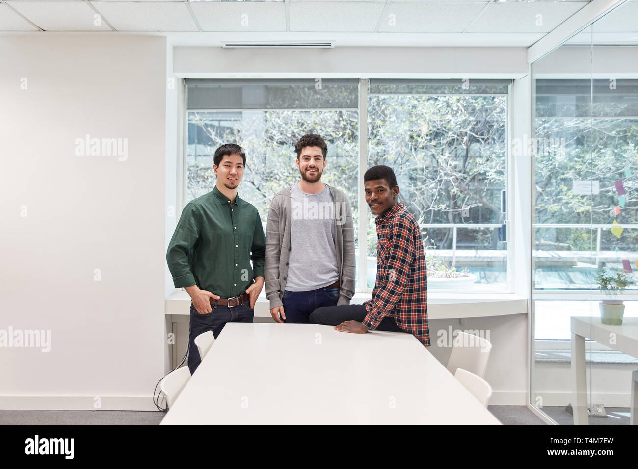 Drei junge Männer, die als Schüler und Freunde im Seminarraum oder coworking Büro Stockfoto
