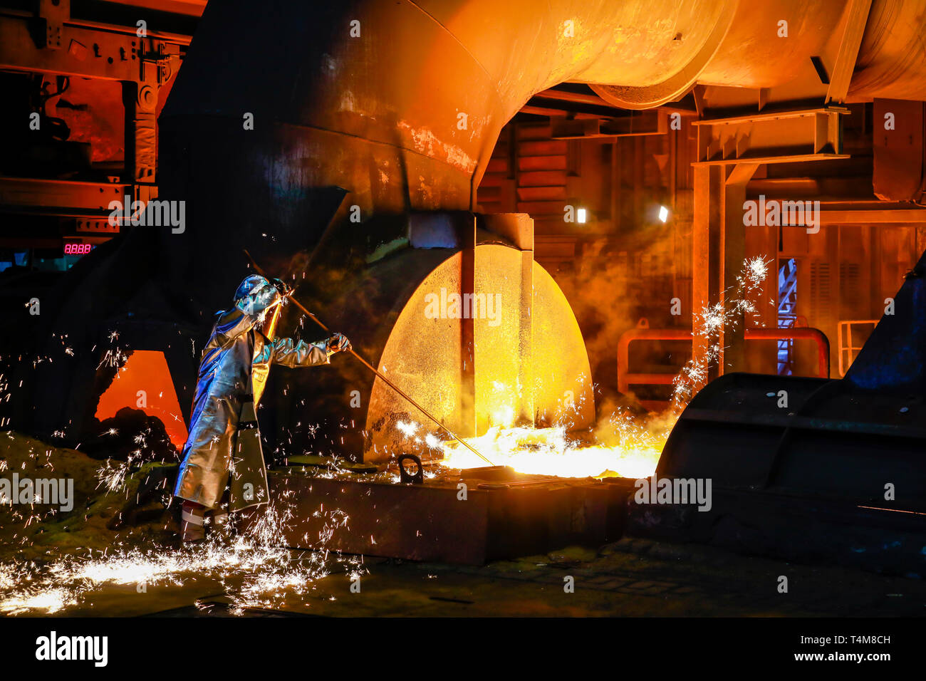Duisburg, Ruhrgebiet, Nordrhein-Westfalen, Deutschland - ThyssenKrupp Stahl, ein Stahlarbeiter in einem Schutzanzug ist ein 1500 Grad heiß Roheisen Probe Stockfoto