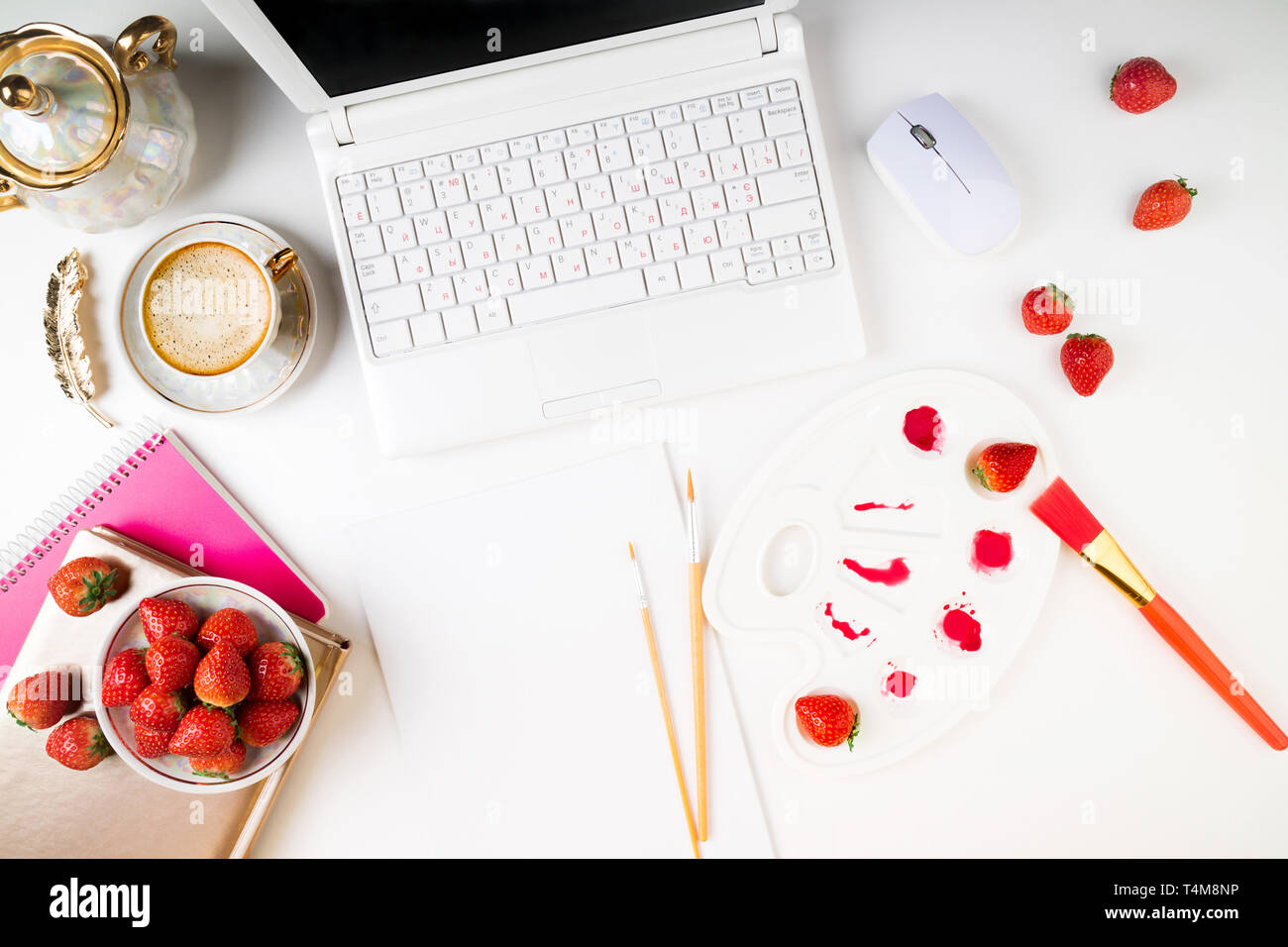 Flach Arbeitsbereich mit Laptop, Kaffeetasse, Erdbeeren und Zubehör auf weißem Hintergrund. Ansicht von oben Artist home Arbeitsplatz. Platz kopieren Stockfoto