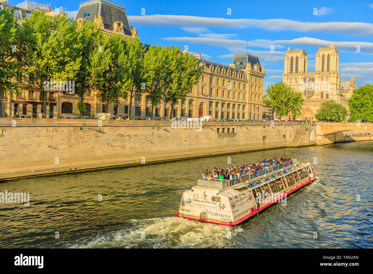 Paris, Frankreich, 1. Juli 2017: Bateaux-Mouches mit vielen touristischen während einer Reise bei Sonnenuntergang auf dem Fluss Seine mit der Kathedrale von Notre Dame auf der Ile de la Stockfoto