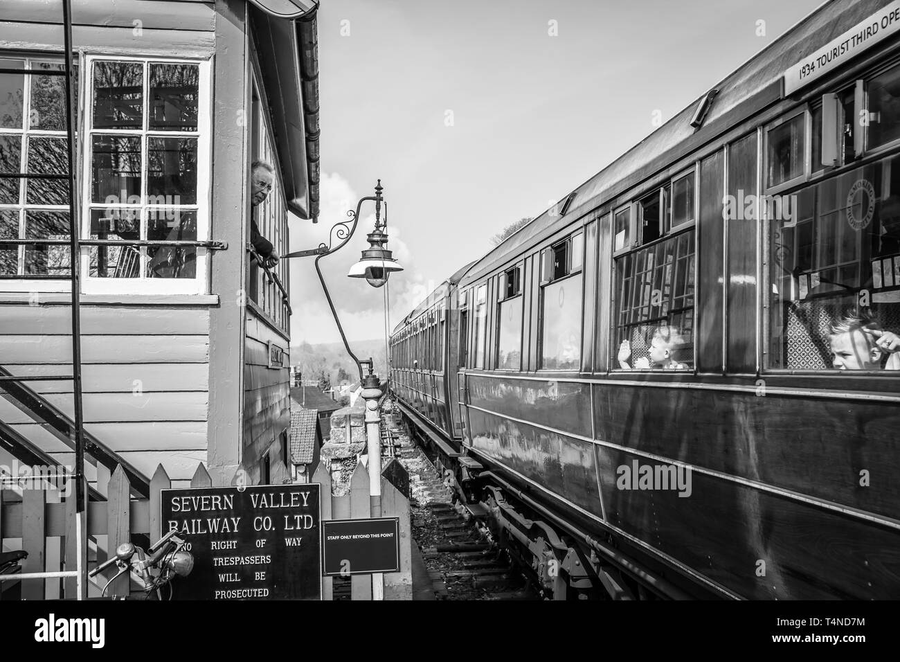 Sie Sichestellen auf Erbe Bahn lehnt aus, um das Fenster "Signal" Kinder, die Fenster, winken von Innen vintage Dampfzug Verlassen der Station zu begrüßen. Stockfoto