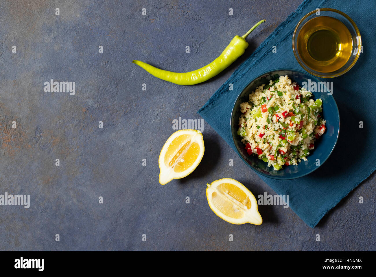 Tabbouleh Salat mit Couscous, Petersilie, Zitrone, Tomaten, Olivenöl. Levantinischen vegetarischen Salat. Libanesische und arabische Küche. Der dunkle Hintergrund. Ansicht von oben. Spa Stockfoto