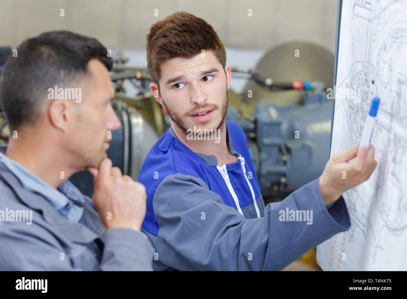 Mann und Lehrling studiert Mathematik Formeln an Bord geschrieben Stockfoto