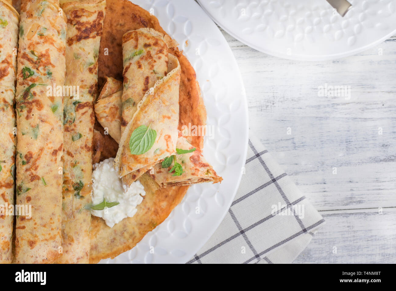 Pfannkuchen mit Dill und weiße Soße auf einem hellen Hintergrund. top ...