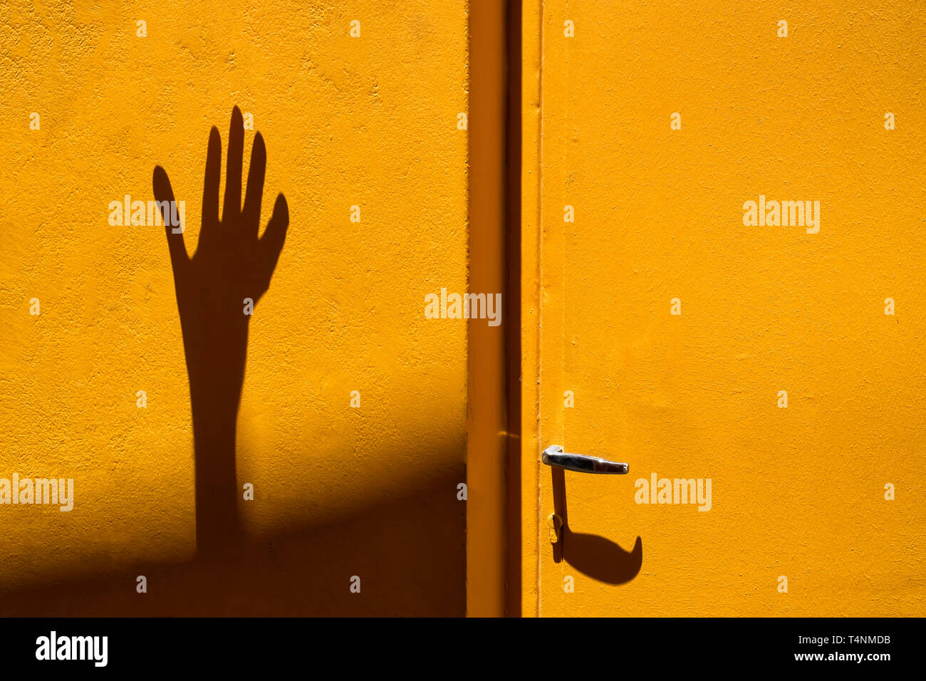 Schatten einer männlichen Hand auf gelbem Hintergrund Stockfoto