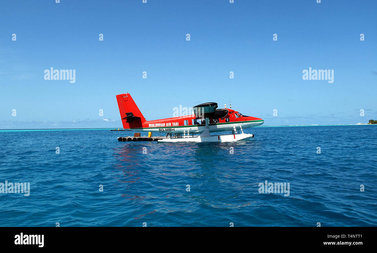 Eine rote Wasserflugzeug von Maldivian Air Taxi ist auf der wunderschönen blauen Meer gelandet. Stockfoto
