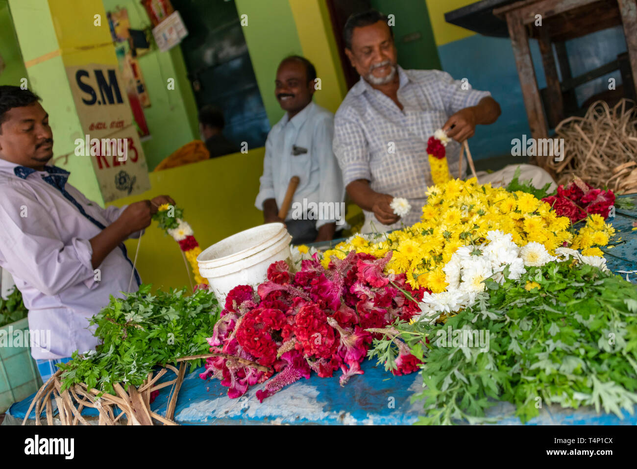 Horizontale Ansicht der Männer die Girlanden an Mattuthavani Blumenmarkt in Madurai, Indien. Stockfoto