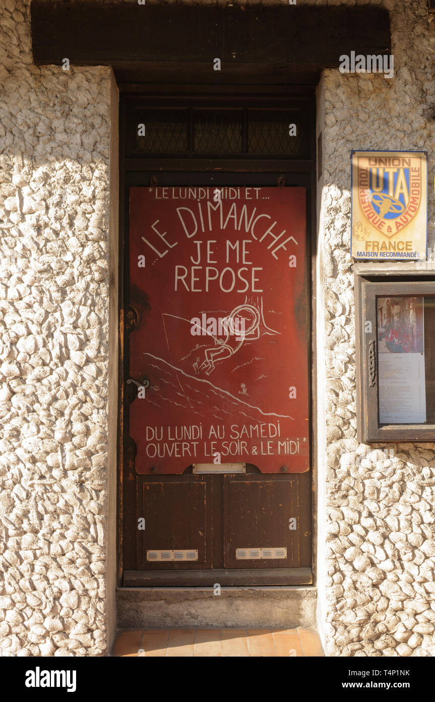 Schild an einer Tür "LE Lundi Midi et le Dimanche Je mich ausruhen. Du Lundi au Samedi Ouvert le Sior & le Midi " Stockfoto