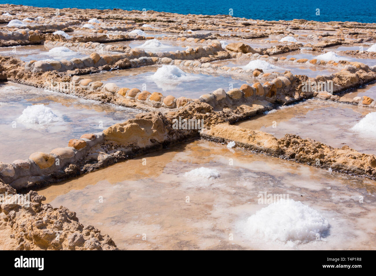 Ernte Meersalz aus dem alten Salinen in Marsalforn, Gozo, Malta. Stockfoto